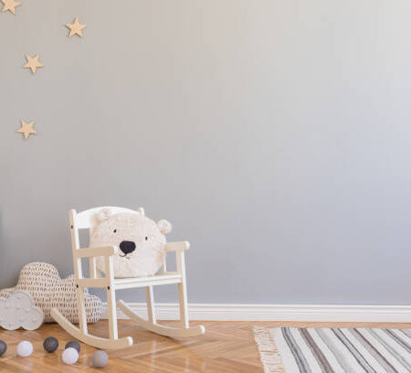 Stylish and modern scandinavian newborn baby interior with mock up photo or poster frame on the white shelf.